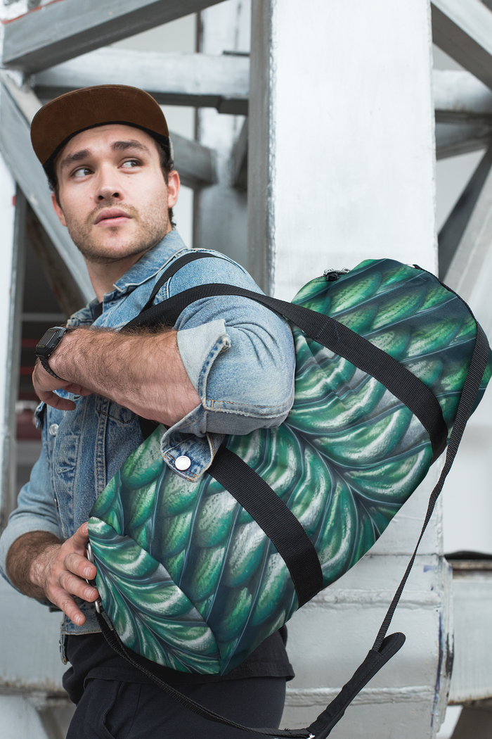 Merman scales duffel bag worn crossbody, black strap with green shell scale print.
