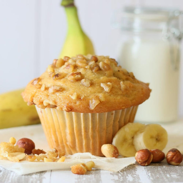 Nut-crunch muffin topped with chopped bits, with banana slices nearby