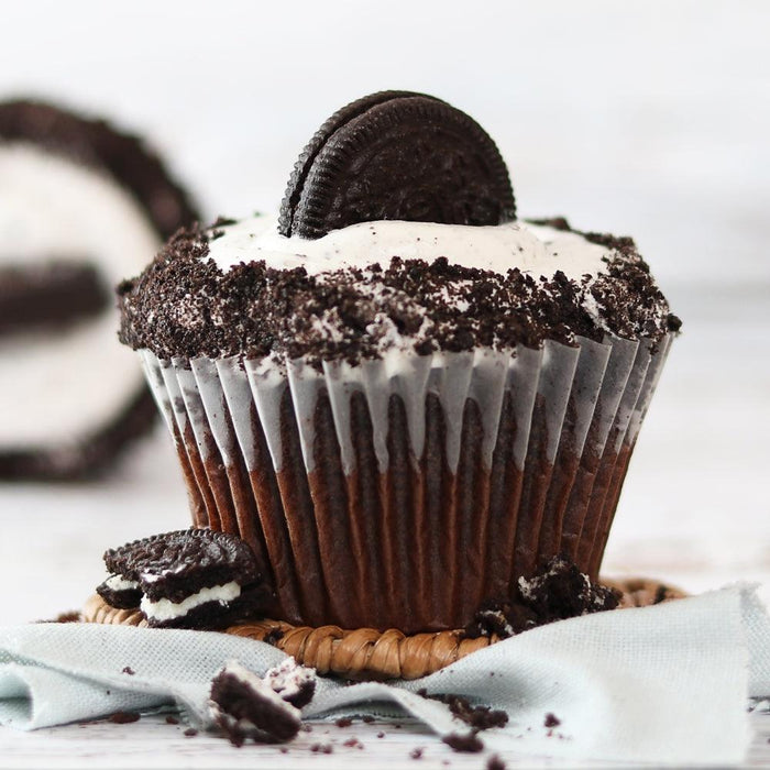 Chocolate cupcake with cookie topping and crumbs, in a gift box setting