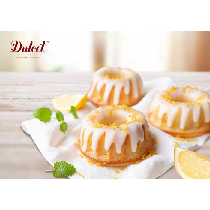 Bundt-style cakes with white icing and citrus garnish on parchment