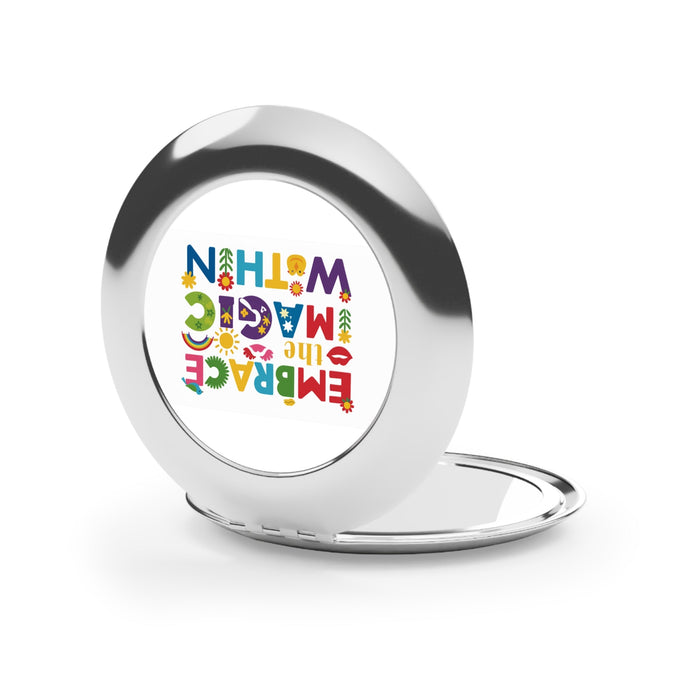 Silver round compact travel mirror, glossy open with colorful graphic on inner surface