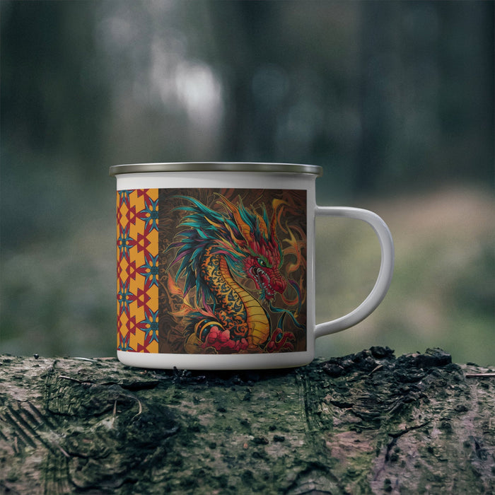 Enamel camping mug with dragon graphic, white handle, silver rim on outdoor log