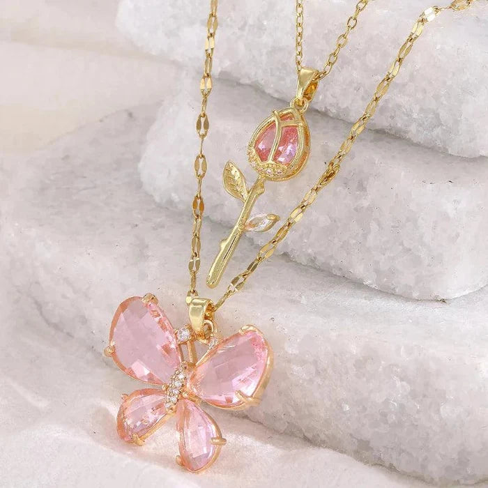 Gold-tone butterfly flower necklace with pink gem petals and rose bud charm