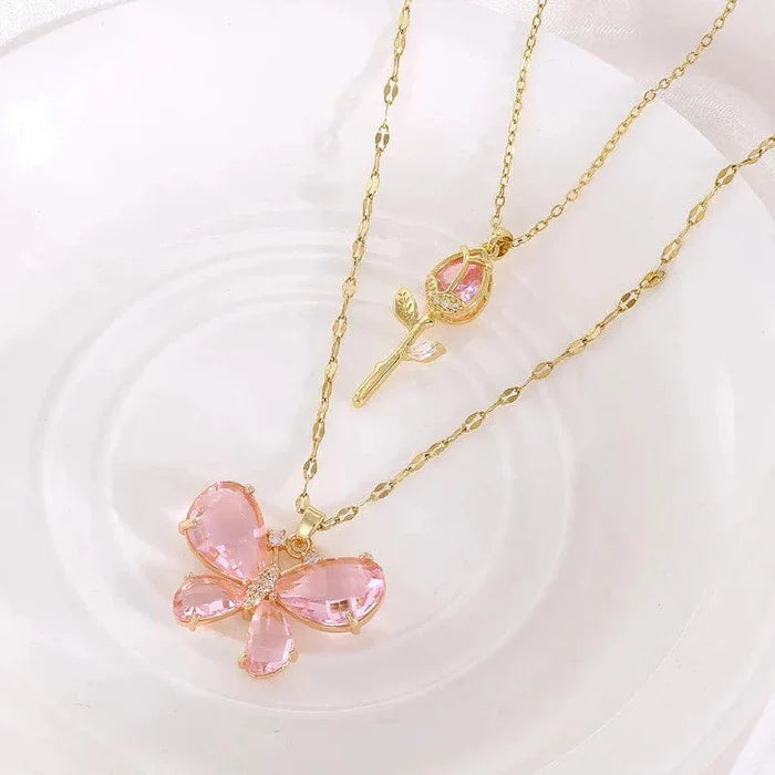 Gold-tone butterfly flower necklace with pink gem petals and rose bud accent pendant