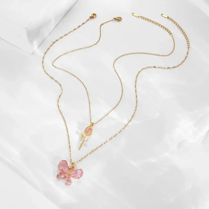 Gold-tone butterfly flower necklace with pink petal pendant and rose bud charm