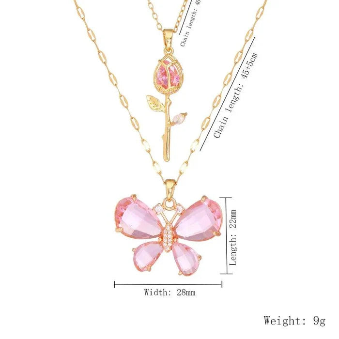 Gold-tone butterfly flower necklace with pink gem petals and rose bud charm