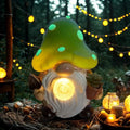 Solar garden gnome statue with green mushroom cap and glowing light, white beard, holding leaves