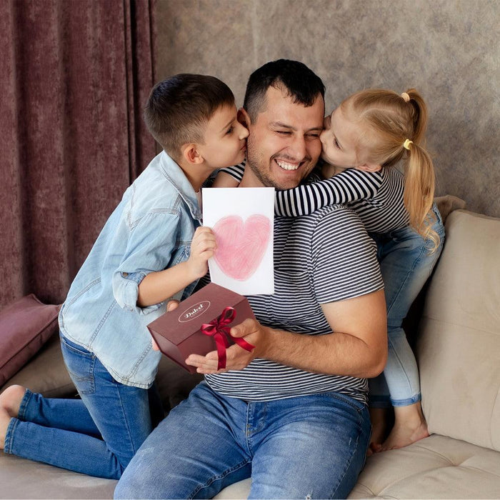 Family holding a pink heart card and gift box together on a couch