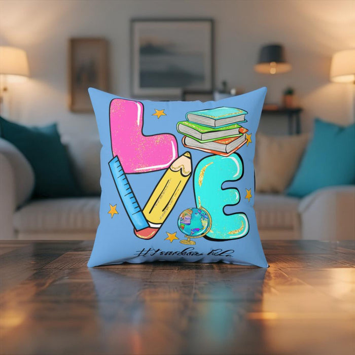 Square faux suede pillow on floor display, light blue print with teacher-themed school items and alphabet