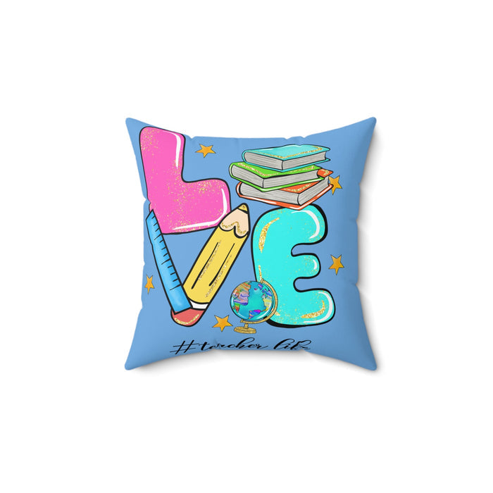 Square faux suede pillow with light blue background and colorful school graphic: pink teacher, books, pencil, globe