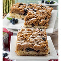 Blueberry crumb cake slices with crumb topping, white icing drizzle, and blueberries