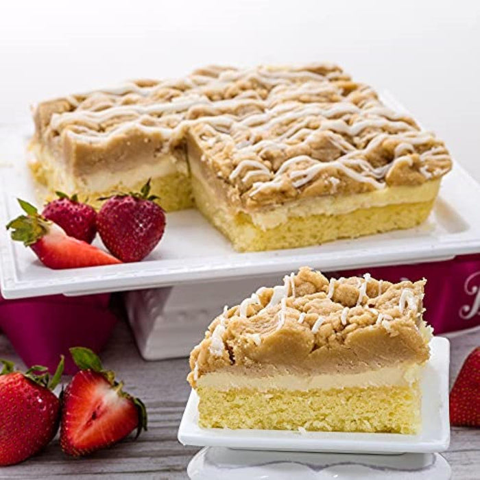 Cheese crumb cake slice with crumb topping and strawberries on serving tray