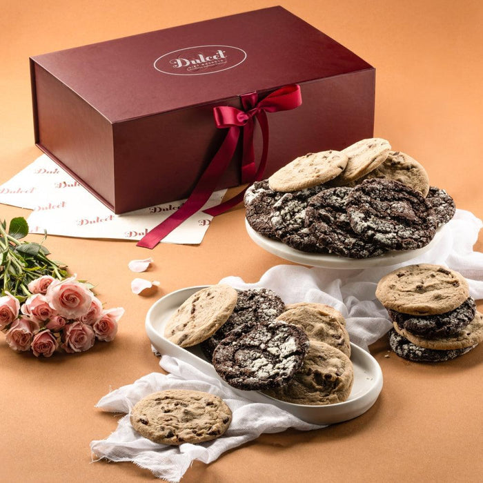 Chocolate cookie gift box with red ribbon bow and assorted chocolate chip crinkle cookies