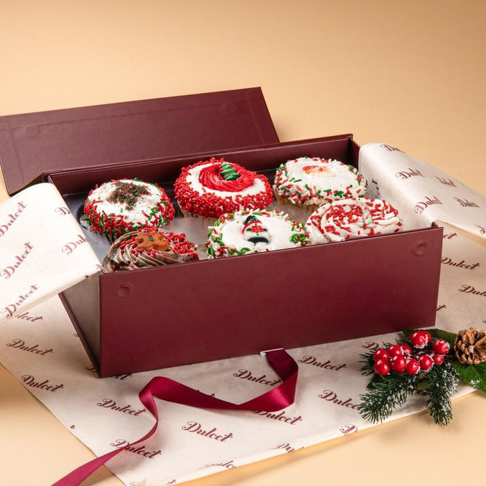 Assorted cupcakes in burgundy gift box, swirled frosting with holiday sprinkles
