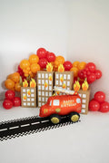 Fire truck balloon centerpiece with balloon arch, house panels, and “Happy Birthday” banner