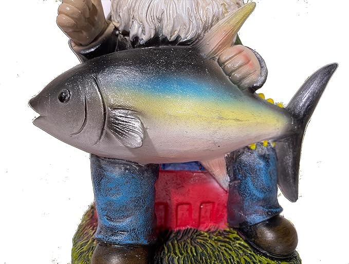 Fishing gnome statue close-up holding gray-blue tuna fish