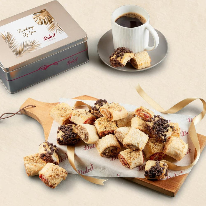 Rugelah gift assortment on tray with ribbon, tin, and coffee cup