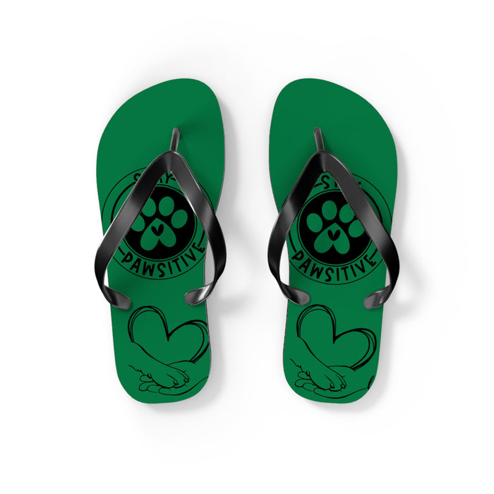 Pair of green flip-flops with black toe straps and paw-print artwork with “PAWSITIVE”