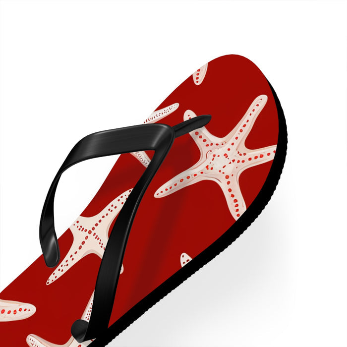 Red starfish flip flop with black thong strap and textured sole, side view