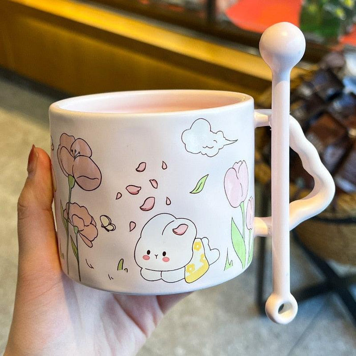 White bunny flower mug with a sleeping cat and pink flower doodles, spoon-shaped handle