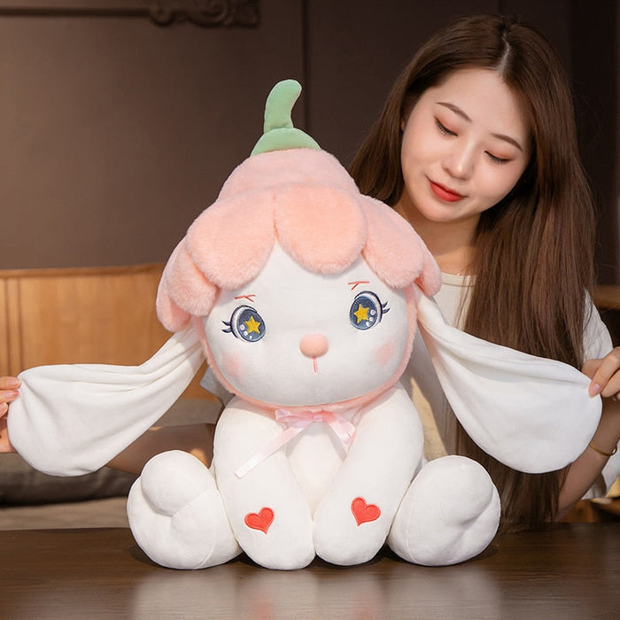 Flower bunny plushie held upright, green ears, blue star eyes, pink bow, and heart patches
