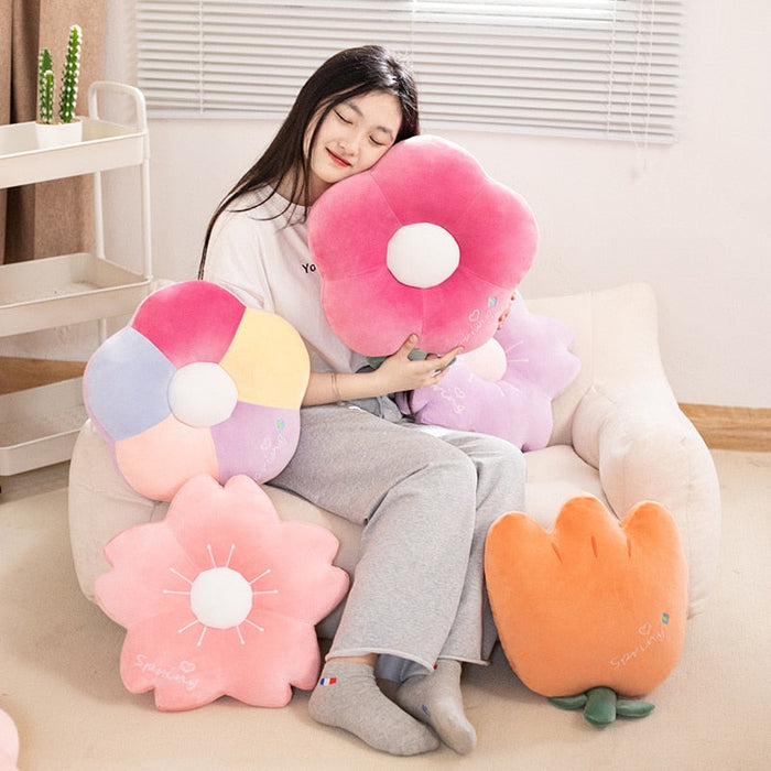 Colorful flower plush set with white centers surrounding seated child holding pink plush