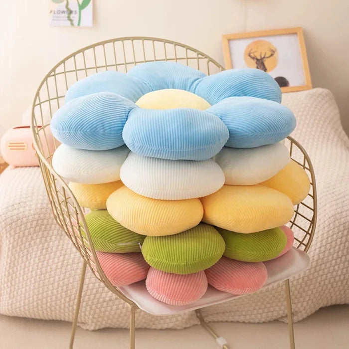 Flower-shaped plush pillow with blue petals, pale yellow inner center, and layered design
