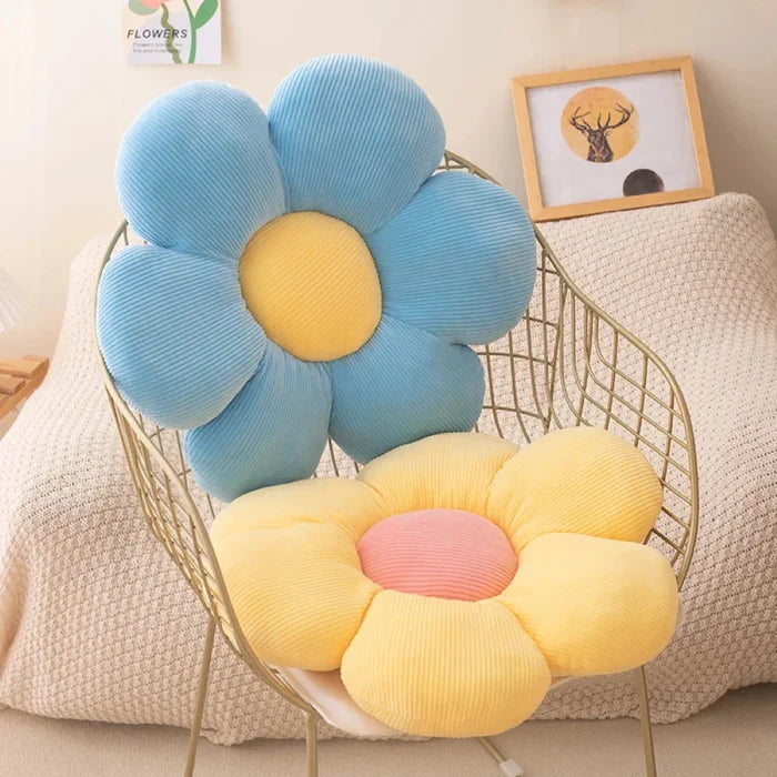 Flower-shaped plush pillow with light blue petals and a yellow fabric center
