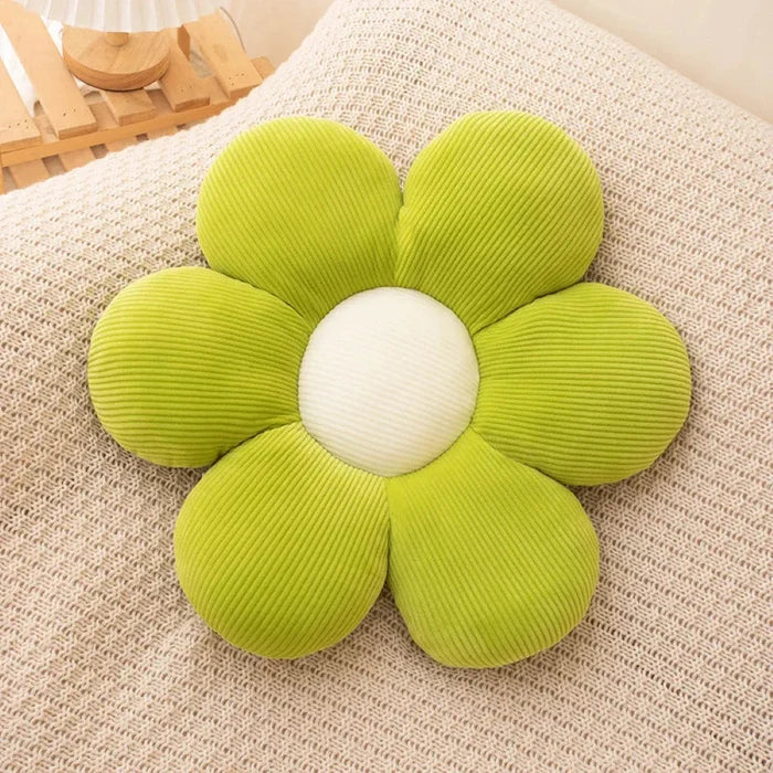 Flower-shaped plush pillow with green petals and a white fabric center