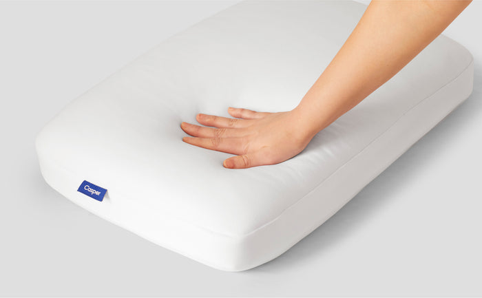 A hand feeling the Casper Foam Pillow with Snow Technology
