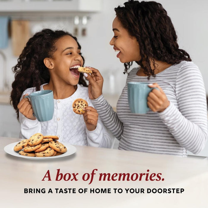 Two people holding mugs and eating assorted cookies