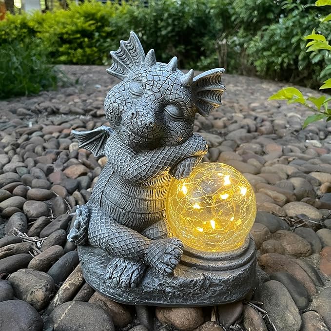 Gray dragon resin figurine sitting and holding a glowing glass orb for outdoor decor