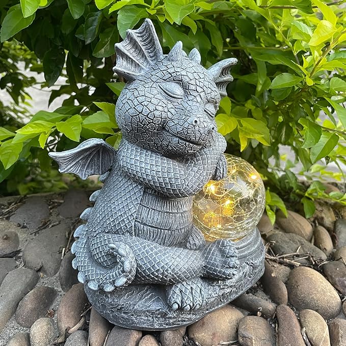 Gray dragon resin statue holding a glowing glass orb, close-up of textured details