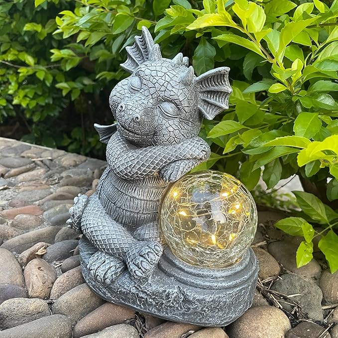 Gray dragon statue sitting with glowing glass ball orb, textured resin surface
