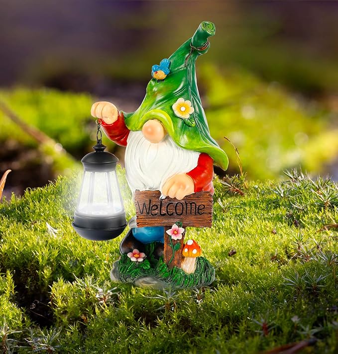 Green garden gnome resin statue with lit solar lantern and welcome sign in grass