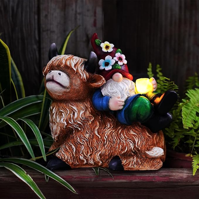 Gnome on highland cow solar garden statue with glowing cup light on wooden bench