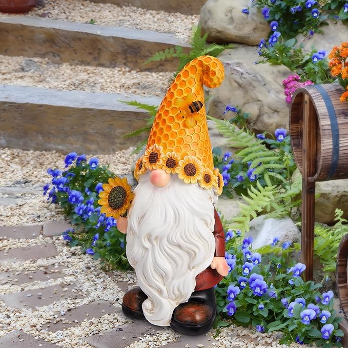 Sunflower garden gnome statue with honeycomb cone hat and white beard, by blue flowers