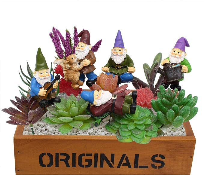 Miniature gnome garden figurines in a wooden box planter with succulents and rocks