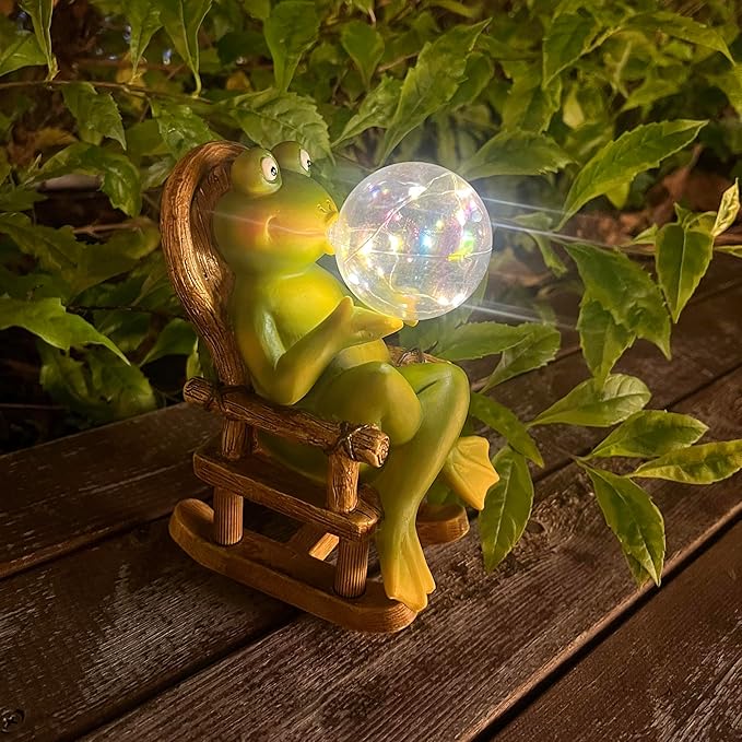 Outdoor frog figurine with glowing bubble light, seated on a wooden bench