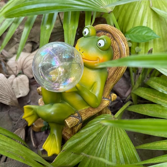 Green frog figurine holding glowing bubble light, perched on a wooden chair