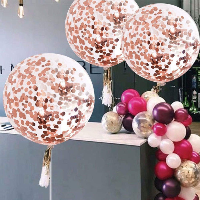 Cluster of giant rose gold confetti balloons with white-pink tassel tails