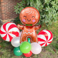 Gingerbread man foil balloon bouquet with candy-cane swirl balloons and green white red accents