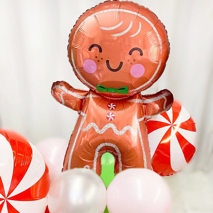 Gingerbread man foil balloon bouquet with candy-cane peppermint swirl and round white balloons
