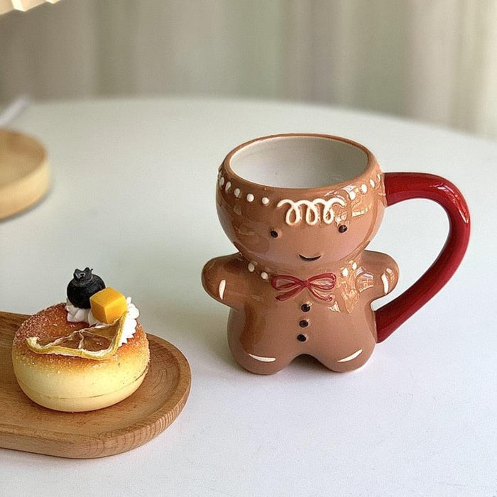 Gingerbread man mug in brown with red bow, dotted buttons, and curved red handle
