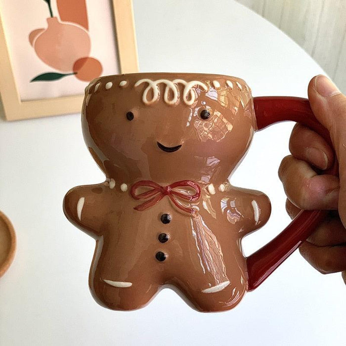 Held gingerbread man mug, brown cookie character with red bow and red handle
