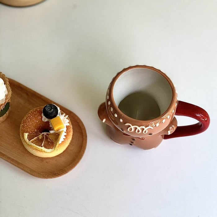 Gingerbread man mug with round rim and dotted trim, red handle on the right