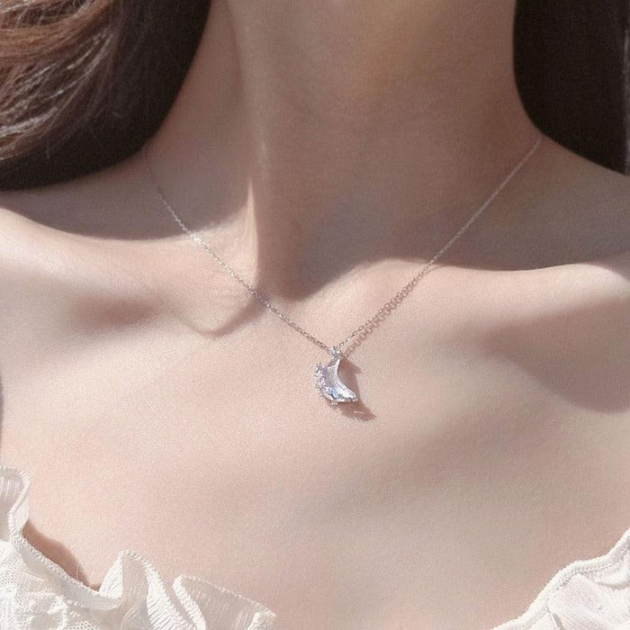 Silver moon pendant necklace with blue iridescent crescent charm centered on thin chain