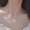 Silver moon pendant necklace with blue iridescent glazed crescent charm hanging on chain
