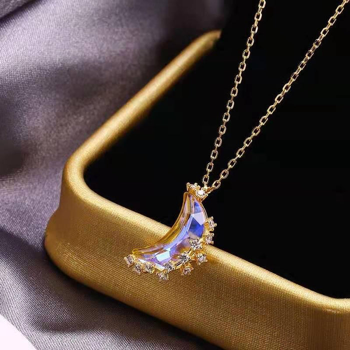 Gold moon pendant necklace with blue iridescent crescent, sparkly star details, chain