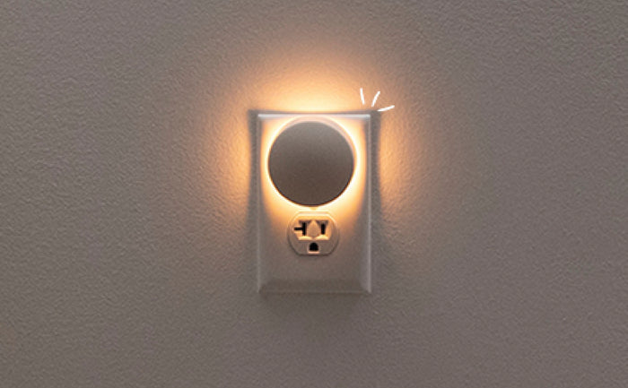 Close-up image of the Glow Nightlight plugged into wall outlet and turned on.